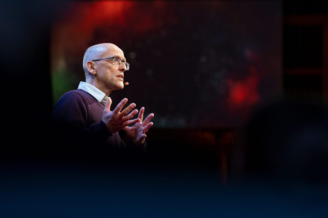 Photograph of Webb presenting on stage